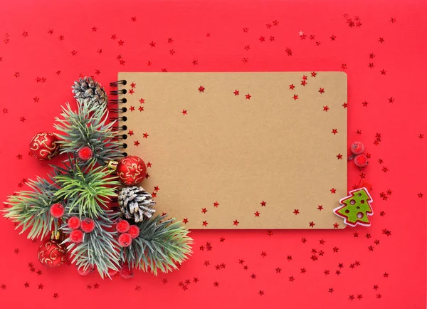 Composición navideña. El cuaderno y las ramas de abeto sobre fondo rojo — Foto de Stock
