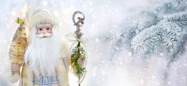 Happy Santa Doll on a background snow-covered fir branches. — Stock Photo, Image