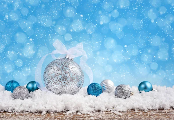Kerstcompositie met feestelijke decoratieve ballen op de sneeuw. — Stockfoto