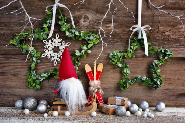 Composición navideña con un gnomo en trineo y decoraciones festivas —  Fotos de Stock