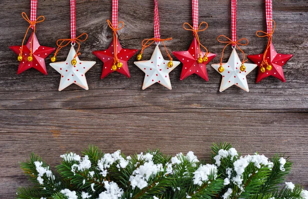 Karla kaplanmış ladin dallarıyla Noel yıldızları — Stok fotoğraf