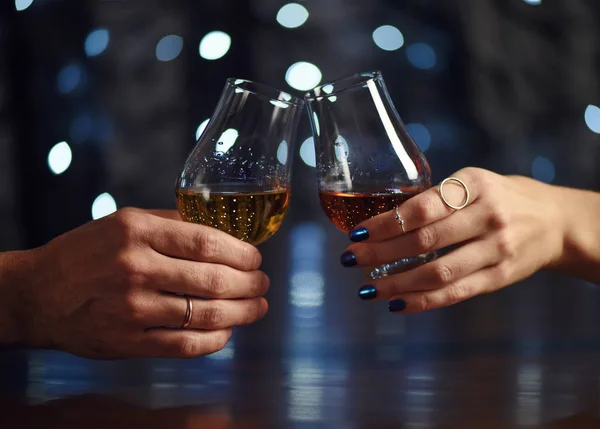 Ett par gör en skål med två glas whisky på festlig bakgrund — Stockfoto