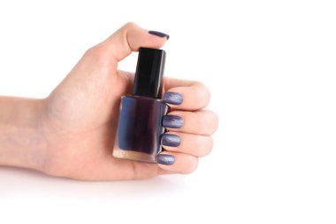 Siyah manikür ve oje şişesi olan bir kadının eli.