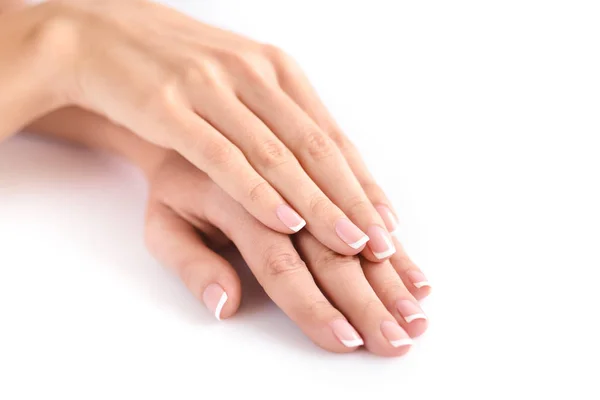 Belle mani donna con manicure francese su uno sfondo bianco — Foto Stock