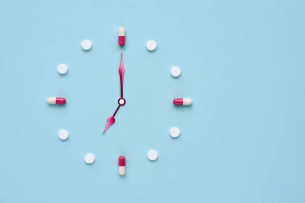 Zegar Stworzony Tabletek Kapsułek Pastelowym Niebieskim Tle Właściwy Czas Przyjmowanie — Zdjęcie stockowe