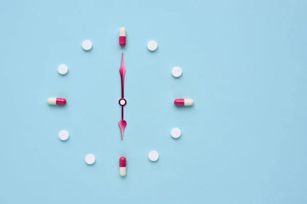 Zegar Stworzony Tabletek Kapsułek Pastelowym Niebieskim Tle Właściwy Czas Przyjmowanie — Zdjęcie stockowe
