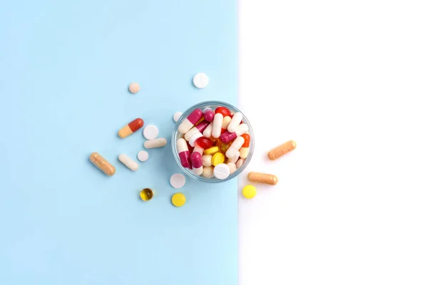 Een Glas Vol Pillen Tabletten Capsules Blauwe Witte Achtergrond Bovenaanzicht — Stockfoto