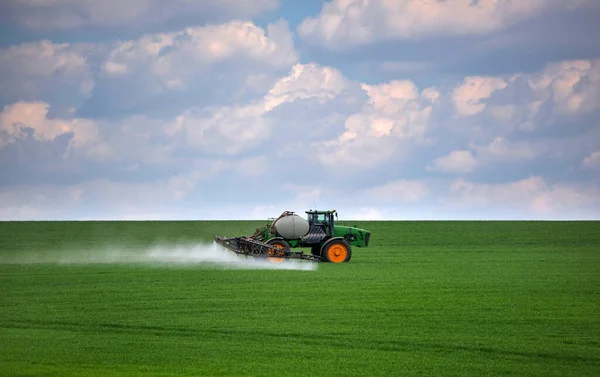 トラクターは緑の小麦のフィールドを噴霧 農作業 — ストック写真