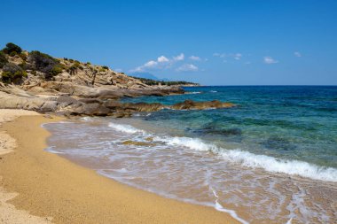 Plajı, kayaları ve şeffaf suyu olan güzel bir deniz manzarası. Sithonia, Halkidiki, Yunanistan.