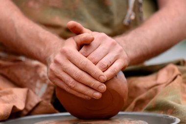 Potter çömlek çarkında seramik demlik yapıyor.