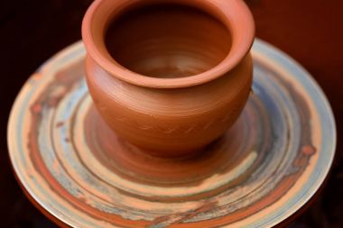 Potter çömlek çarkında seramik demlik yapıyor.