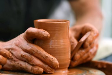 Potter çömlek çarkında seramik demlik yapıyor.