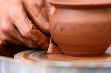 Potter çömlek çarkında seramik demlik yapıyor.
