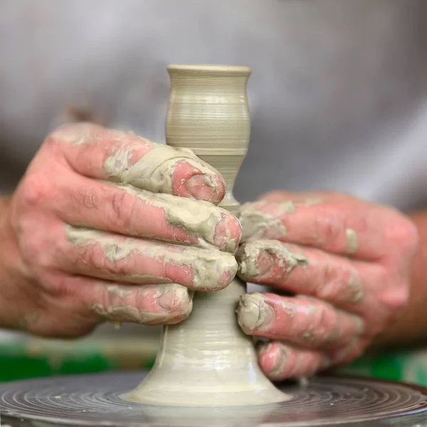 Potter çömlek çarkında seramik demlik yapıyor.