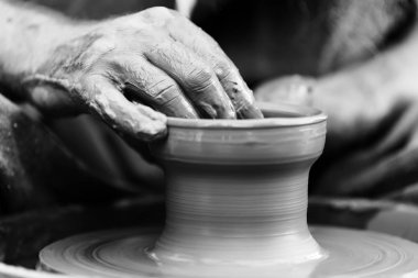 Potter çömlek çarkında seramik demlik yapıyor.