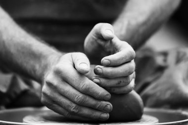 Potter çömlek çarkında seramik demlik yapıyor.