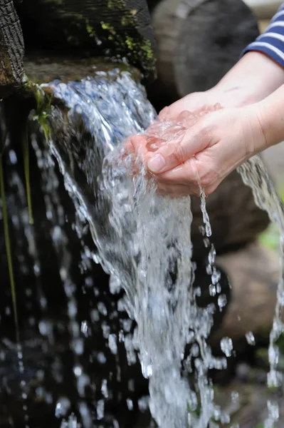 Víz ömlött a nő kezében — Stock Fotó