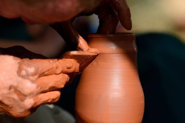 Potter çömlek çarkında seramik demlik yapıyor.