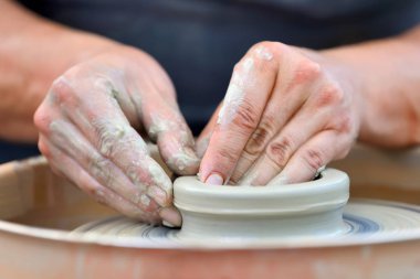 Potter çömlek çarkında seramik demlik yapıyor.