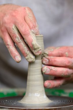 Potter çömlek çarkında seramik demlik yapıyor.