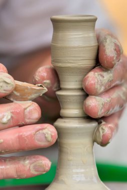 Potter çömlek çarkında seramik demlik yapıyor.