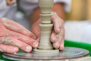 Potter çömlek çarkında seramik demlik yapıyor.