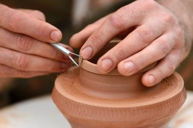 Potter çömlek çarkında seramik demlik yapıyor.