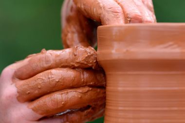 Potter çömlek çarkında seramik demlik yapıyor.