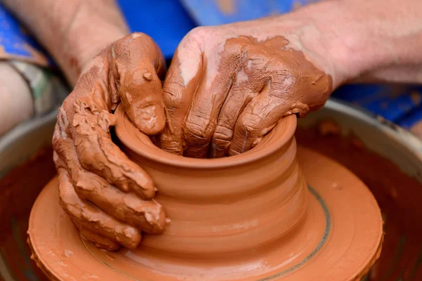Potter çömlek çarkında seramik demlik yapıyor.