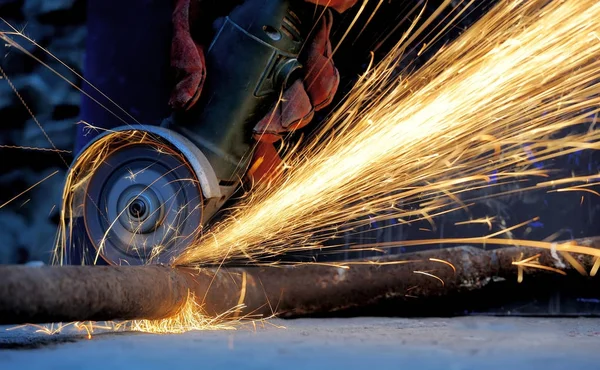 Worker cutting metal with grinder — Stock Photo, Image