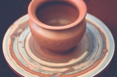 Potter çömlek çarkında seramik demlik yapıyor.