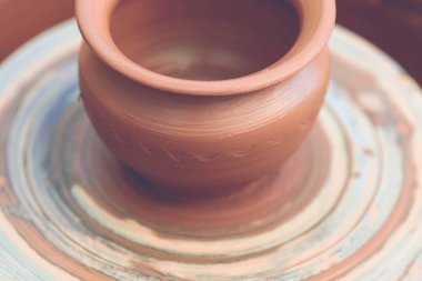 Potter çömlek çarkında seramik demlik yapıyor.