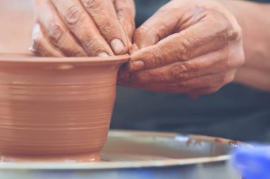 Potter çömlek çarkında seramik demlik yapıyor.
