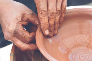 Potter çömlek çarkında seramik demlik yapıyor.