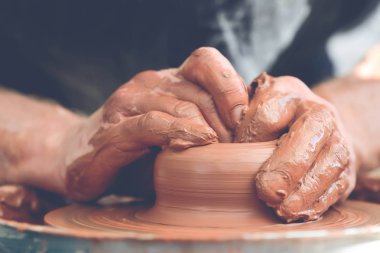 Potter çömlek çarkında seramik demlik yapıyor.