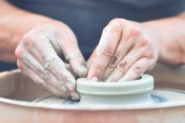 Potter çömlek çarkında seramik demlik yapıyor.