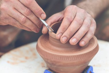 Potter çömlek çarkında seramik demlik yapıyor.