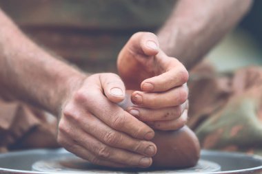 Potter çömlek çarkında seramik demlik yapıyor.