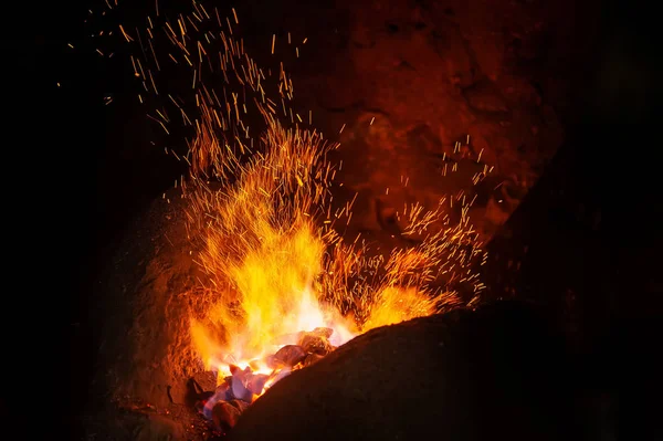 Chispas de un fuego sobre un fondo negro — Foto de Stock