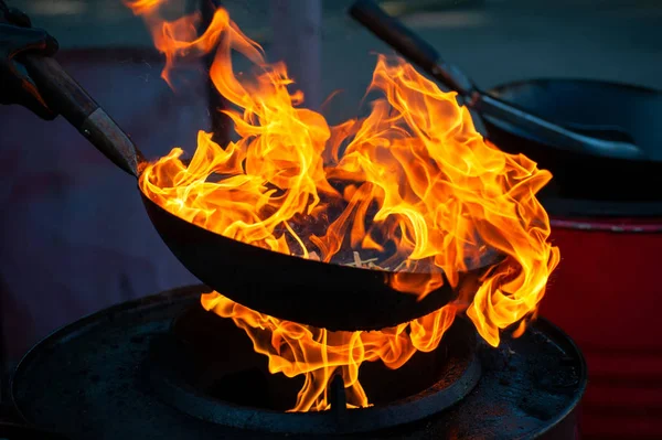 Chef cooking with fire in frying pan — Stock Photo, Image