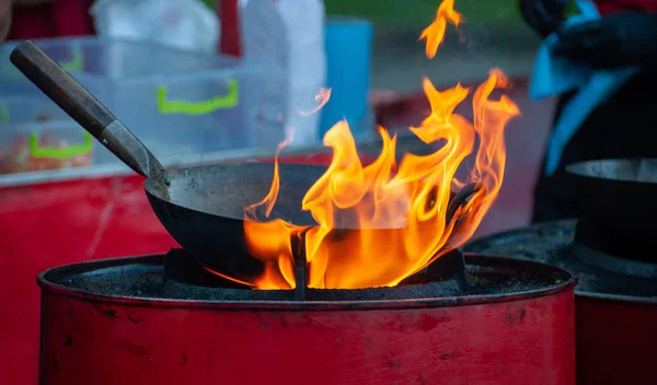 Chef cuisinier avec feu dans une poêle — Photo