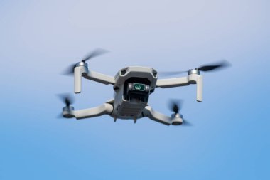 Mavi gökyüzü arka planında güneşli bir günde uçuş sırasında drone Quadcopter