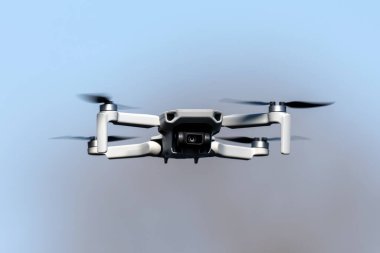 Mavi gökyüzü arka planında güneşli bir günde uçuş sırasında drone Quadcopter