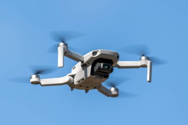 Mavi gökyüzü arka planında güneşli bir günde uçuş sırasında drone Quadcopter