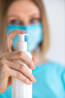 Üniformalı kadın doktor ya da hemşire ellerine dezenfektan sabun sürüyor. Dezenfeksiyon ve el yıkama. Virüs ve bakterilere karşı koruma