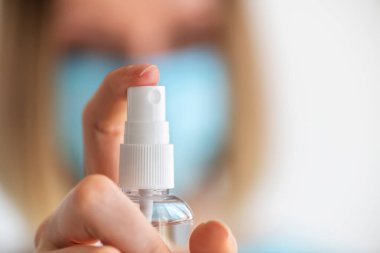 Kadın doktor ya da üniformalı hemşire ellerine dezenfektan spreyi sıkar. Dezenfeksiyon ve el yıkama. Virüs ve bakterilere karşı koruma