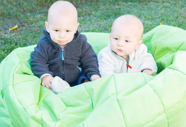 Pokój typu Twin małych dzieci siedzi na worek fasoli — Zdjęcie stockowe