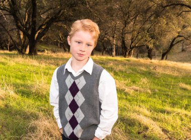 Yeşil alanda duran genç çocuk