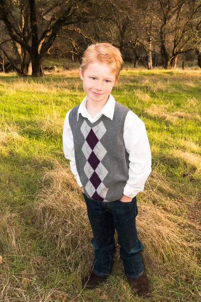 Мальчик, стоящий на зеленом поле — стоковое фото
