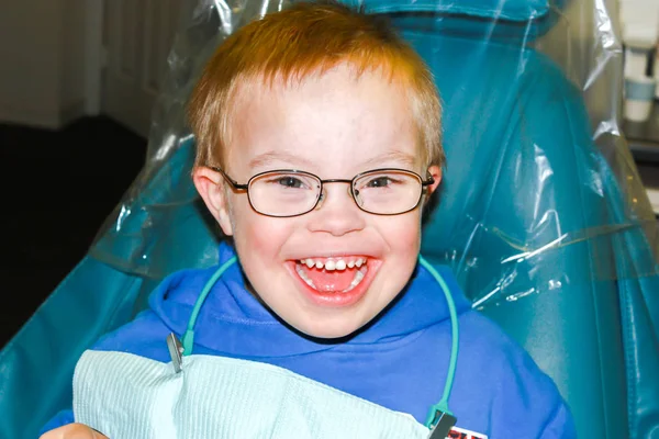 Niño con síndrome de Down sentado en silla de dentista Fotos de stock libres de derechos